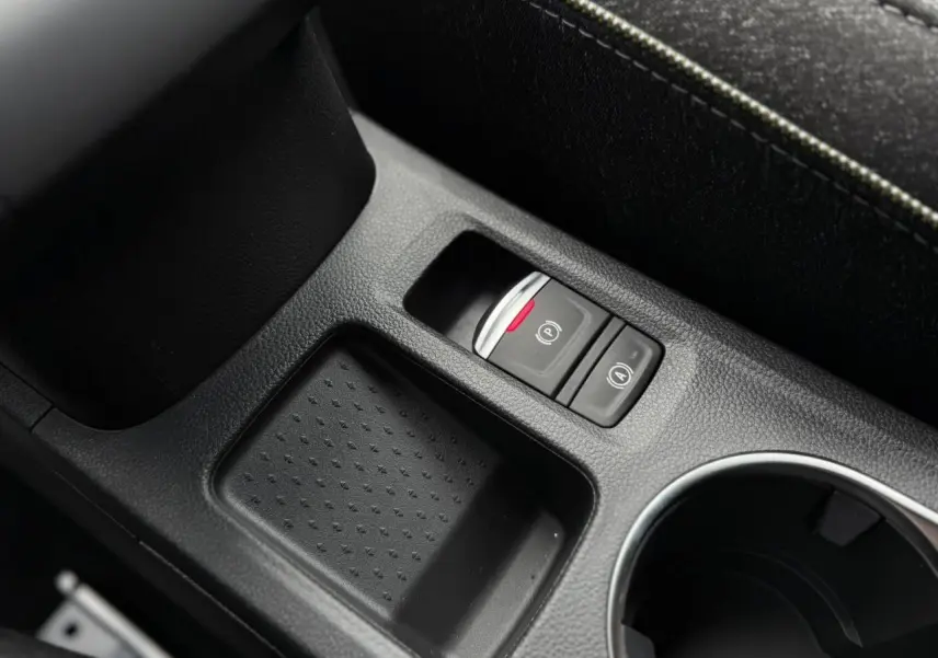 Gros plan sur la console centrale noire du Renault Captur 2026, avec frein à main électrique et rangement.