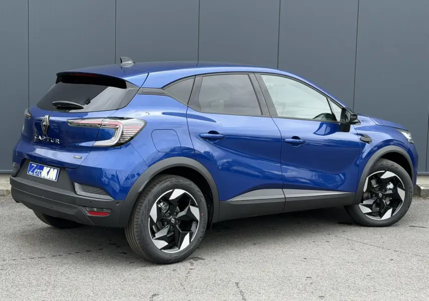Vue 3/4 arrière droite du Renault Captur 2026 bleu Iron avec jantes aluminium 18 pouces Black Hole.