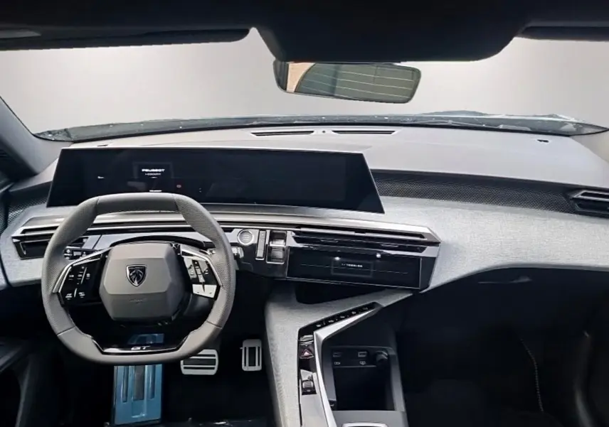 Vue intérieure avant du Peugeot 5008 Hybrid noir 2026, avec volant multifonction et tableau de bord numérique.
