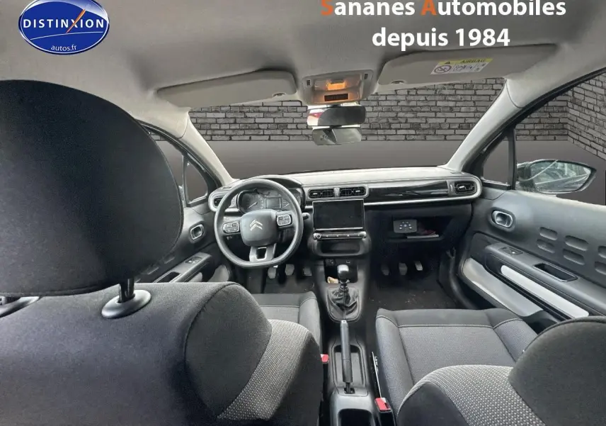 Vue intérieure avant du Citroën C3 noir 2023, montrant le tableau de bord moderne et volant multifonction.