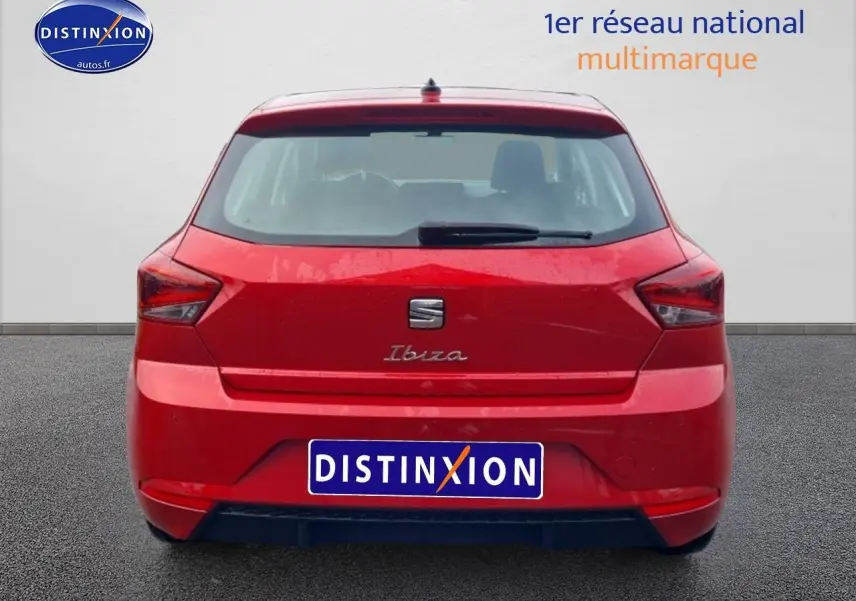 Vue arrière d'une SEAT Ibiza rouge désir 2025 avec feux angulaires et logo centré sur un fond neutre.