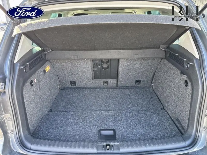Coffre ouvert vu de l'arrière d'un Volkswagen Tiguan gris Crypton, montrant un espace de chargement propre et bien agencé.