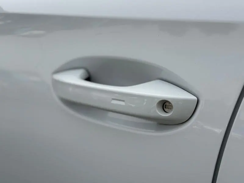 Poignée de porte côté gauche en gros plan sur CUPRA Formentor blanc Nevada métallisé 2025, finition lisse et moderne.