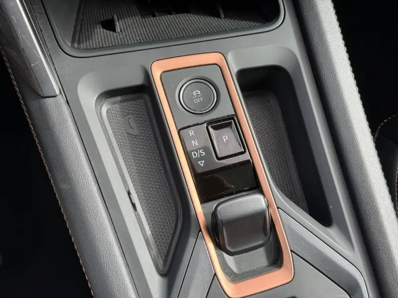 Gros plan sur la console centrale avec la commande de boîte automatique et cadre cuivré du CUPRA Formentor blanc Nevada 2025.