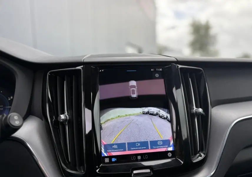 Écran tactile central affichant la caméra de recul du Volvo XC60 T6 AWD PHEV rouge, vue intérieure avant.