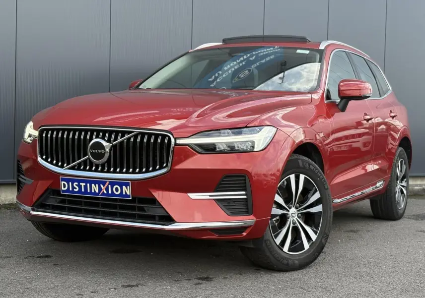 Vue 3/4 avant droit du Volvo XC60 T6 AWD PHEV rouge Fusion avec calandre chromée et jantes alliage 18 pouces.