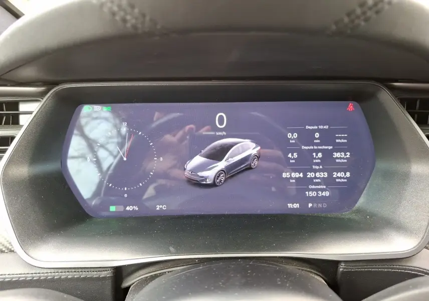 Vue du tableau de bord numérique du Tesla Model X 100D 2018, affichant une illustration grise du véhicule et les données de conduite.