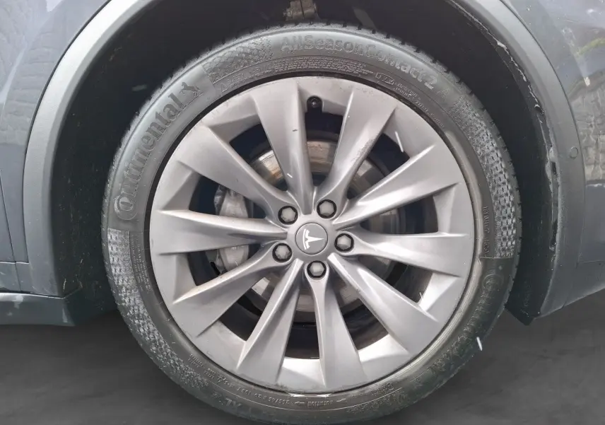 Gros plan sur la jante alliage 20 pouces gris clair du côté avant droit d’un Tesla Model X 100D gris foncé.