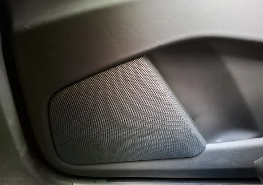 Gros plan sur le haut-parleur intégré à la porte intérieure d’un Tesla Model X 100D gris foncé.