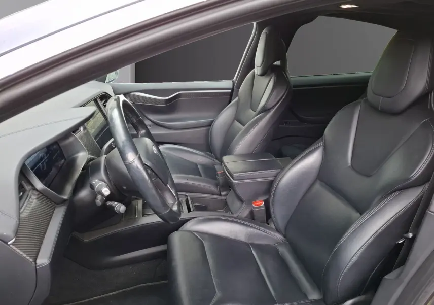 Vue intérieure côté conducteur du Tesla Model X 100D 2018, sièges en cuir noir et tableau de bord moderne.