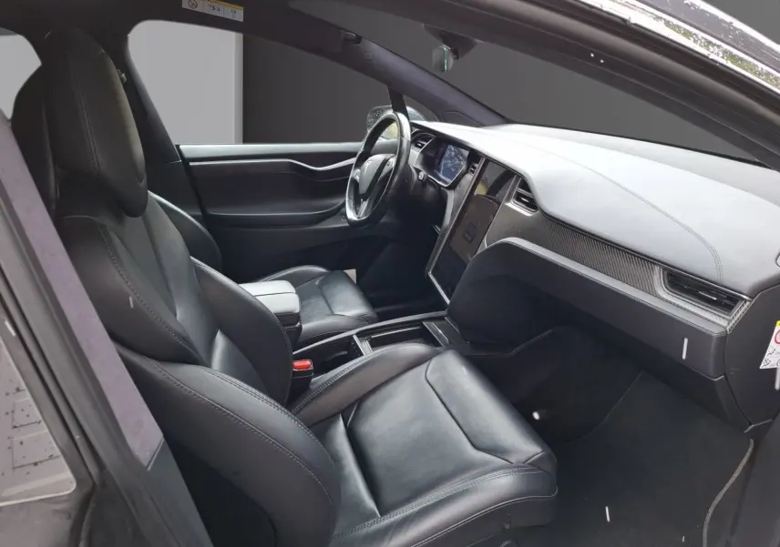 Vue intérieure côté conducteur du Tesla Model X 100D 2018 avec sièges cuir noirs et tableau de bord moderne.