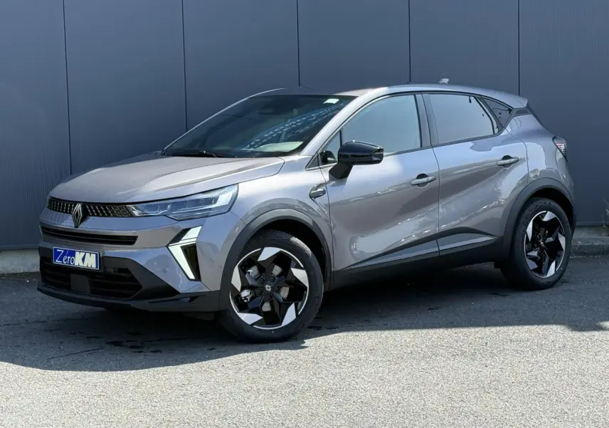 Renault Captur 2026 gris Cassiopée en 3/4 avant droit, avec jantes noires et détails modernes sur carrosserie.
