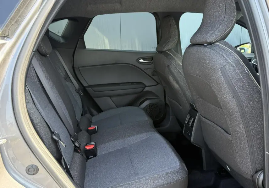Vue intérieure arrière côté gauche du Renault Captur gris Cassiopée, montrant les sièges tissu et les portières.