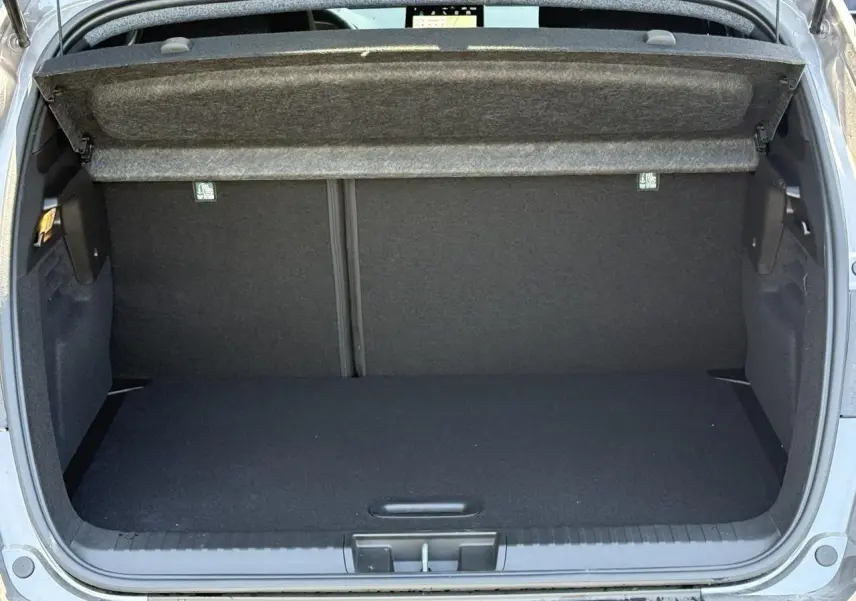 Coffre ouvert vu de l'arrière d'un Renault Captur gris Cassiopée, espace de chargement vide et propre.