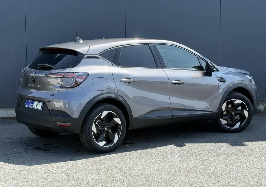 Renault Captur gris Cassiopée vu de profil côté droit, avec jantes 18 pouces bicolores et vitres surteintées.