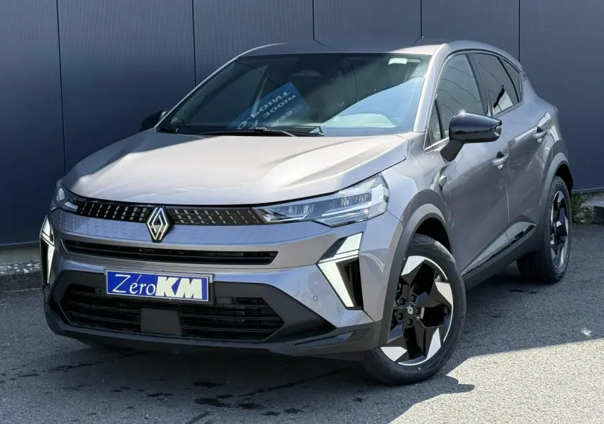 Renault Captur 2026 gris Cassiopée en 3/4 avant droit, avec jantes 18 pouces Black Hole et calandre moderne.