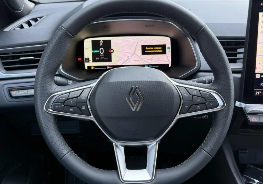 Vue rapprochée du volant noir perforé de Renault Captur 2026 avec tableau de bord numérique et commandes intégrées.