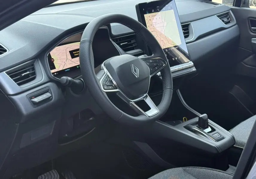 Vue intérieure côté conducteur du Renault Captur 2026, volant multifonction et grand écran tactile central.