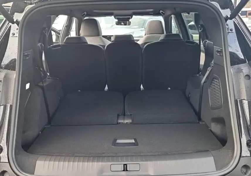 Coffre ouvert d’un Peugeot 5008 noir, vue arrière montrant les sièges rabattus et l’espace de chargement plat.