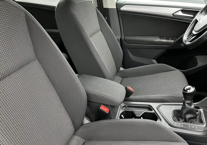 Intérieur avant du Volkswagen Tiguan 2018, sièges tissu gris et levier de vitesse manuel visible côté droit.