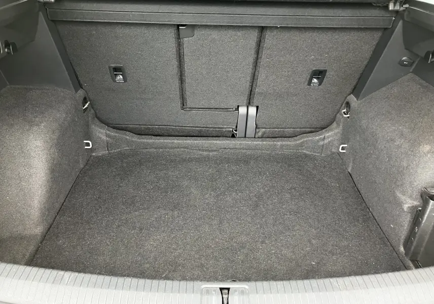 Coffre spacieux et vide du Volkswagen Tiguan blanc 2018, vue intérieure arrière avec revêtement gris foncé.