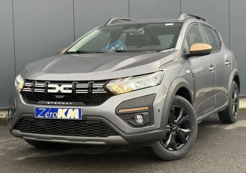 Dacia Sandero Stepway gris schiste en 3/4 avant droit avec jantes noires et coques de rétroviseurs bronze.
