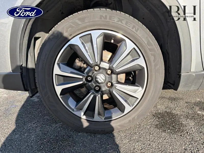 Gros plan sur la jante alu grise du Suzuki Vitara Galactic Gray 2022, mettant en valeur le logo central et le pneu Nexen.