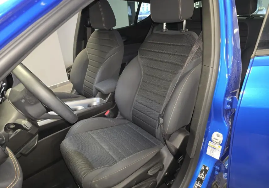 Vue intérieure côté conducteur de l'Alfa Romeo Tonale bleu 2024, siège tissu noir Carbone avec surpiqûres beige.