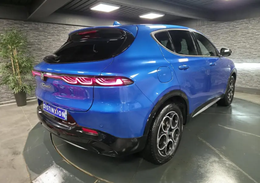 Vue 3/4 arrière droite de l'Alfa Romeo Tonale 1.3 PHEV bleu métallisé avec feux arrière LED et jantes alliage 18 pouces.