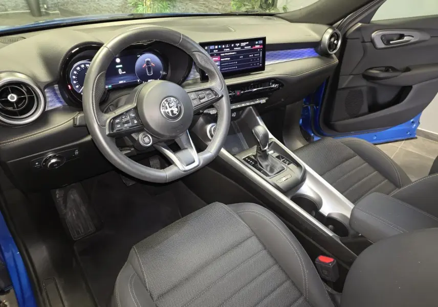 Intérieur de l'Alfa Romeo Tonale bleu, vue côté conducteur, volant sport cuir et tableau de bord digital.