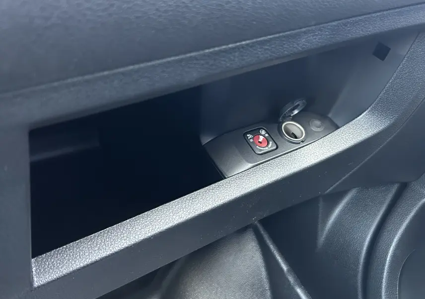 Gros plan sur la prise 12V et le bouton de désactivation de l'airbag passager dans le rangement intérieur du Citroën Jumpy Cabine Approfondie noir.