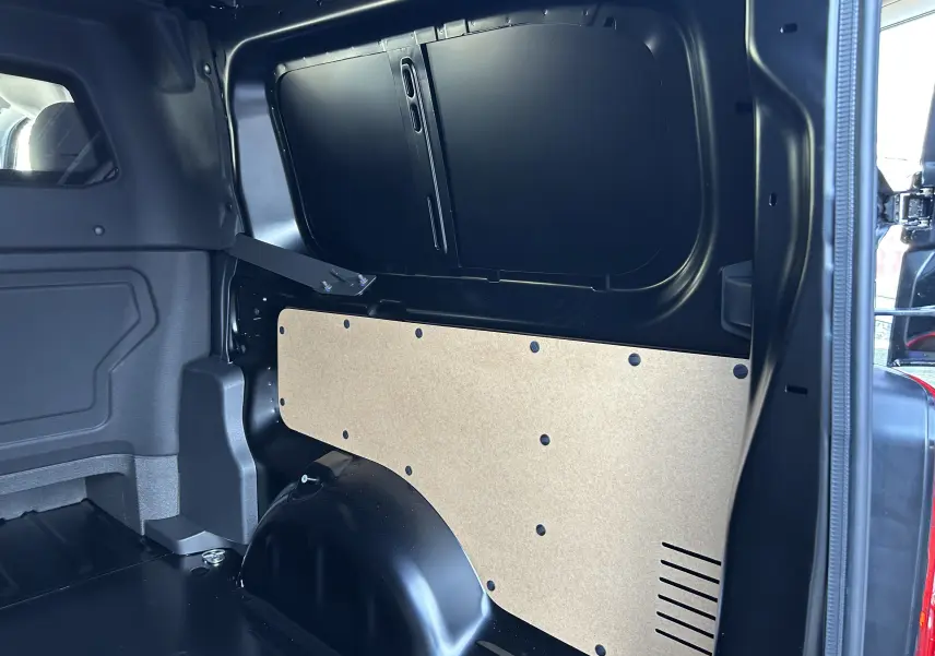 Vue intérieure côté droit de l’espace de chargement noir du Citroën Jumpy Cabine Approfondie 2025 avec panneau de protection beige.