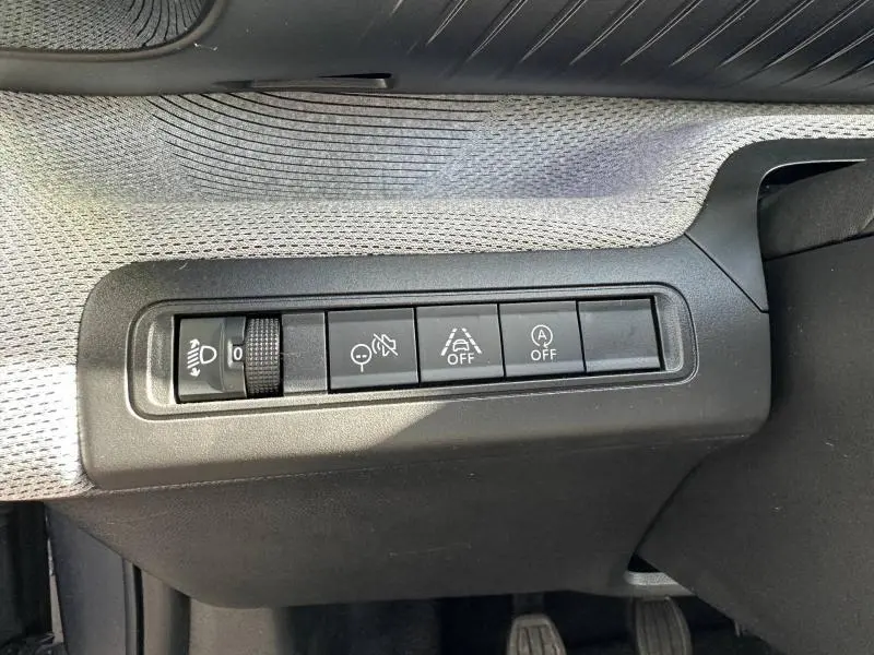 Gros plan sur les commandes de sécurité et réglage des phares dans l’habitacle gris d’une Citroën C3 1.2 Turbo 2025.