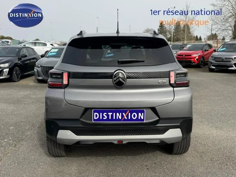 Vue arrière d'une Citroën C3 1.2 Turbo 100ch gris Mercury avec détails noirs et logo central sur un parking.