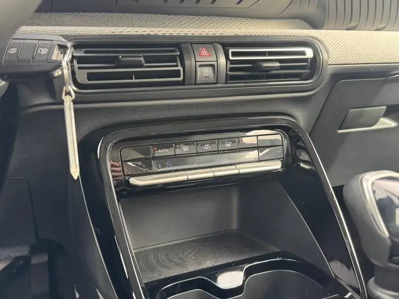 Vue rapprochée de la console centrale de la Citroën C3 1.2 Turbo 100ch gris Mercury avec commandes climatisation et clé insérée.