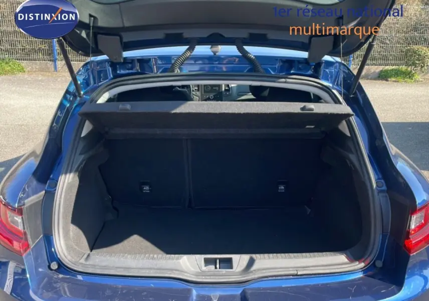 Coffre ouvert vu de l'arrière d'une Renault Mégane 1.3 TCE 140ch Business bleu cosmos métal, intérieur noir visible.