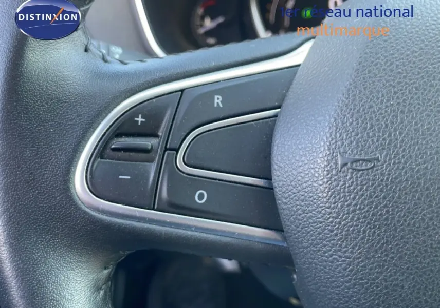 Gros plan sur les commandes du volant noir de la Renault Mégane 2019, mettant en valeur les boutons de régulation.