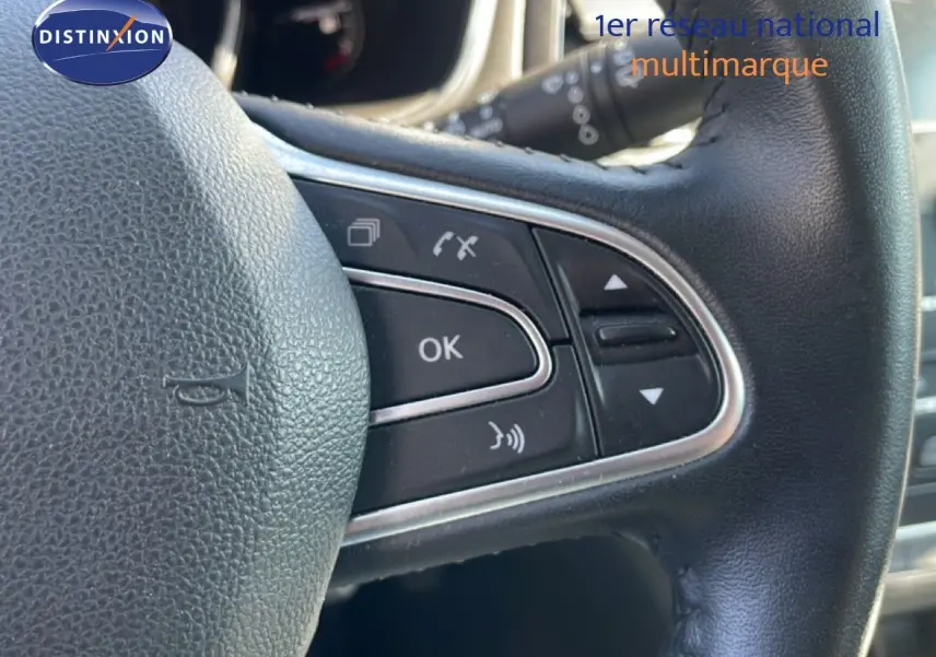 Gros plan sur les commandes multifonctions du volant en cuir noir de la Renault Mégane 2019, version Business.