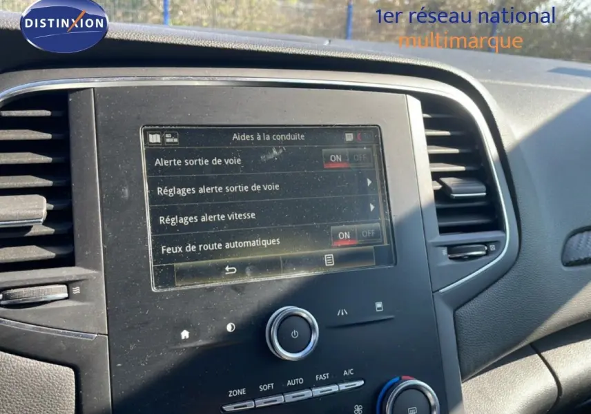 Vue rapprochée de l’écran tactile central du tableau de bord d’une Renault Mégane 2019, affichant les aides à la conduite.