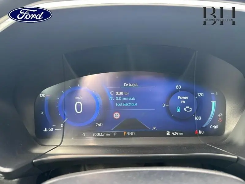 Tableau de bord numérique du Ford Kuga 2023, affichage vitesse et informations trajets en bleu et noir.