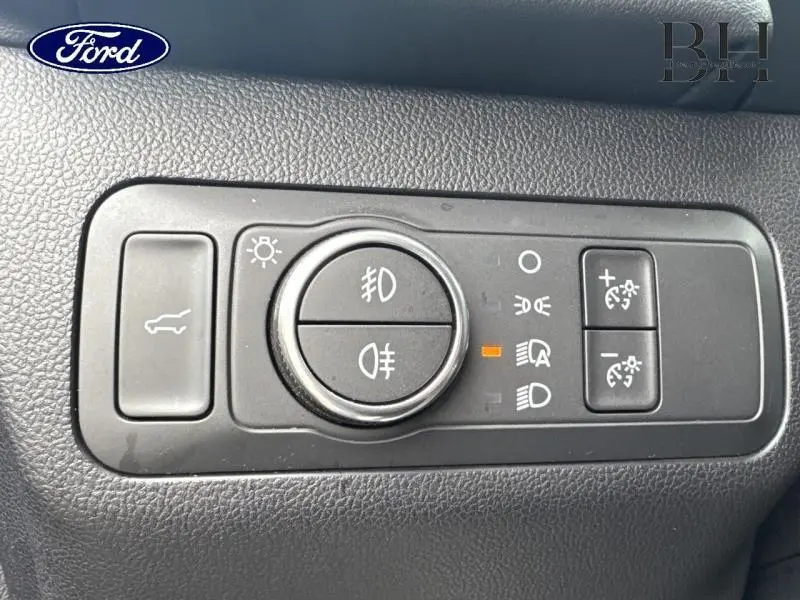 Gros plan sur les commandes d’éclairage et réglage du tableau de bord du Ford Kuga 2023, finition Vignale.