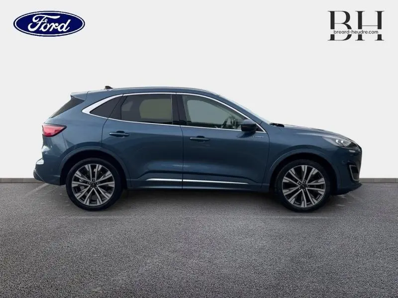 Vue latérale droite du Ford Kuga 2023 bleu azur métallisé avec jantes alliage 20 pouces et toit ouvrant panoramique.