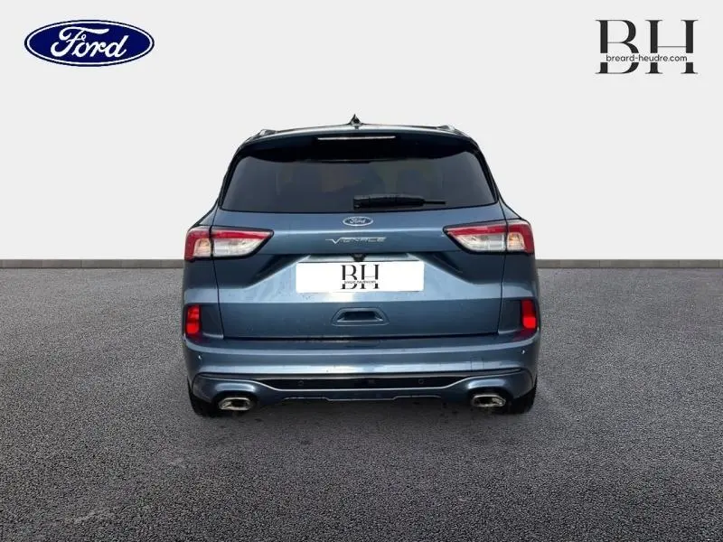 Vue arrière d'un Ford Kuga 2023 bleu azur métallisé avec double sortie d'échappement et toit ouvrant panoramique.