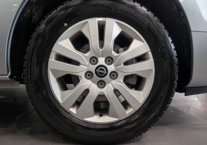 Gros plan sur la jante alliage argentée du Nissan Primastar Combi gris Highland, mettant en valeur le logo central Nissan.
