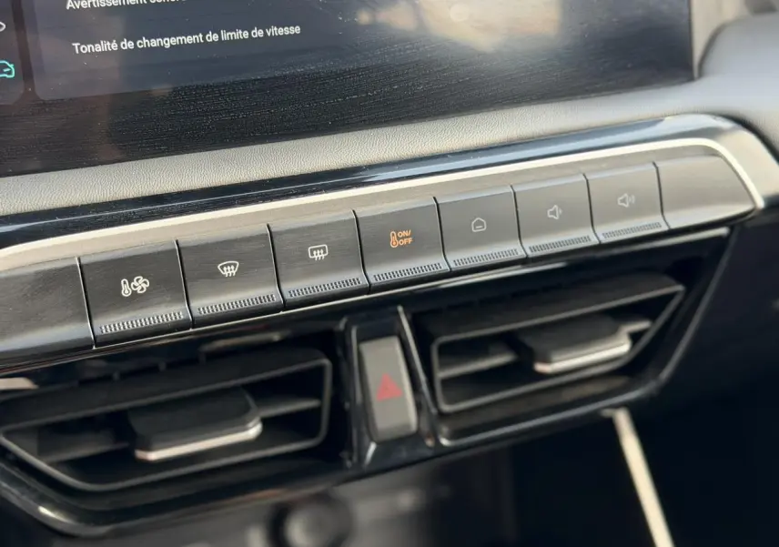 Gros plan sur la console centrale du MG3 1.5 Hybrid+ 195 Comfort, montrant les commandes de climatisation et les aérateurs noirs.