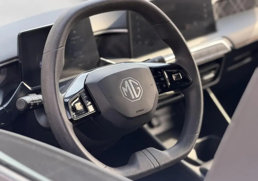 Vue rapprochée du volant multifonction noir avec logo MG au centre dans l’habitacle du MG3 2024.