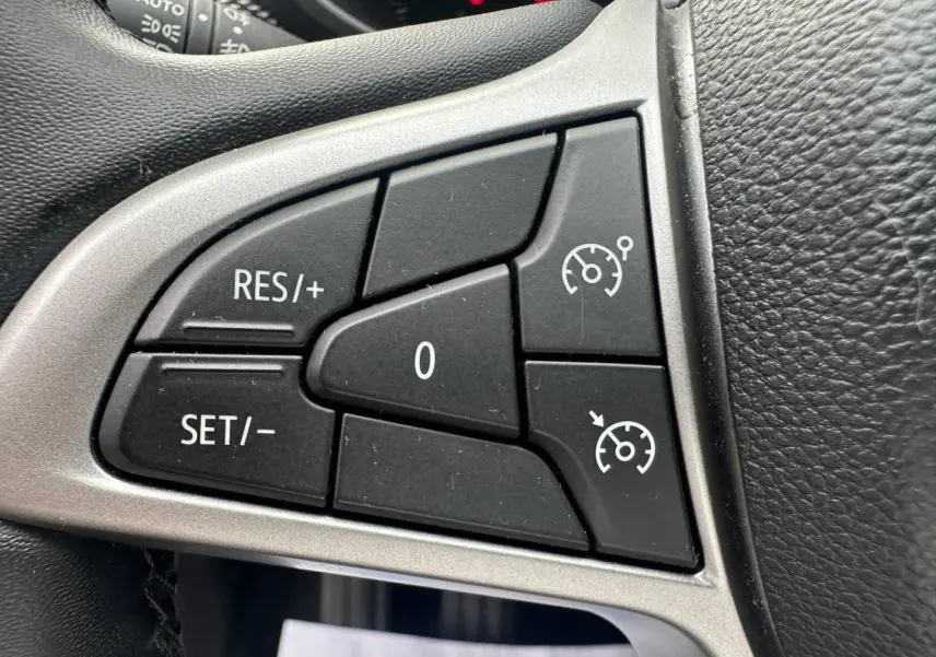 Gros plan sur les commandes de régulateur de vitesse noires sur le volant du Dacia Jogger 2025.