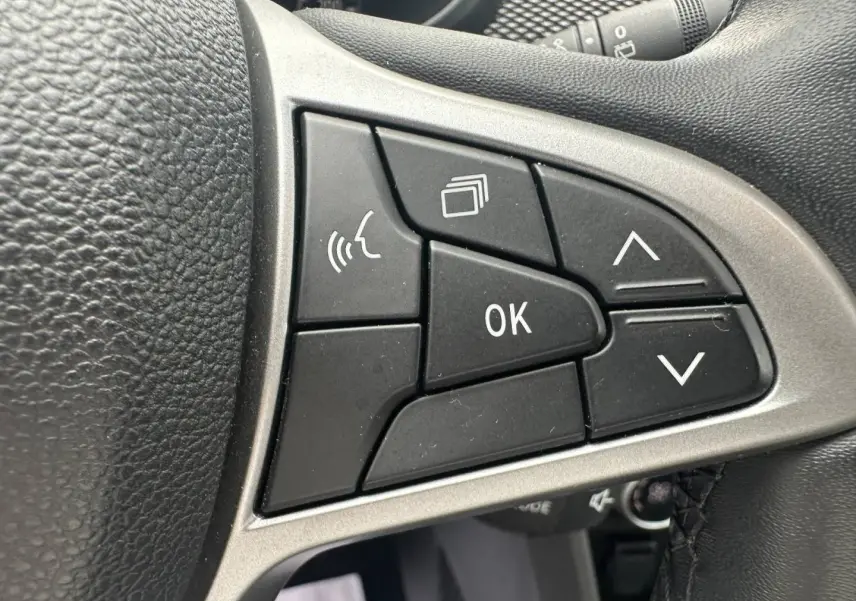 Gros plan sur les commandes multifonctions noires du volant du Dacia Jogger 2025, finition Expression.