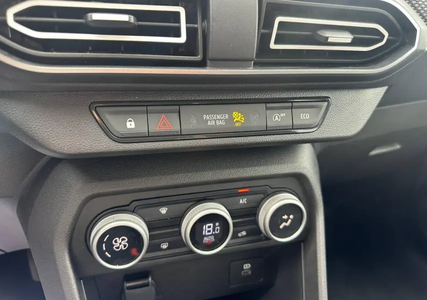 Détail de la console centrale du Dacia Jogger 2025 avec commandes climatisation et boutons fonctionnels en noir mat.