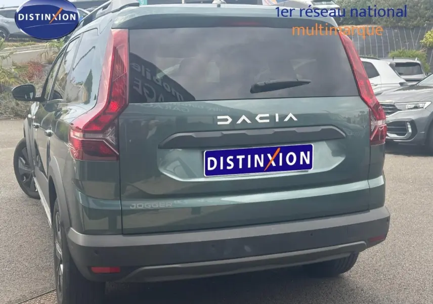 Vue arrière d'un Dacia Jogger 2025 vert cèdre métallisé avec feux arrière verticaux et lunette arrière surteintée.